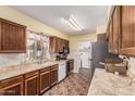 Well-lit kitchen with marble countertops, wooden cabinetry, and stainless steel appliances at 421 S 113Th Way, Mesa, AZ 85208