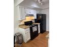 Cozy kitchen with white cabinets, granite countertops, and black appliances at 520 N Stapley Dr # 265, Mesa, AZ 85203