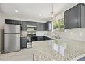 Renovated kitchen featuring granite countertops, stainless appliances, and a stylish lighting fixture at 5602 N 73Rd Ave, Glendale, AZ 85303