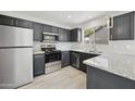 Modern kitchen with stainless steel appliances, granite countertops, and sleek dark cabinetry at 5602 N 73Rd Ave, Glendale, AZ 85303