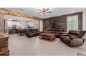 Spacious living room with comfortable leather seating, wood accents, and an open layout to the kitchen at 5659 N 195Th Dr, Litchfield Park, AZ 85340