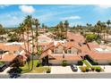 Beautiful single-Gathering home featuring a tile roof, manicured lawn, and mature palm trees under a sunny blue sky at 7115 E Buena Terra Way, Paradise Valley, AZ 85253
