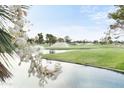 Scenic view of lush golf course with mature trees and water features, enhanced by sprinklers at 7350 N Via Paseo Del Sur -- # N207, Scottsdale, AZ 85258