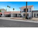 A two-story home with a covered carport, decorative iron balcony, and landscaped front yard at 7632 E Bonita Dr, Scottsdale, AZ 85250