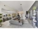 Open-concept living room with tile floors, a modern chandelier, and a view into the kitchen, perfect for entertaining at 10157 E San Salvador Dr, Scottsdale, AZ 85258