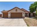 Charming single-story home featuring a terracotta roof, neutral stucco, and a spacious three-car garage at 1443 N Poppy St, Casa Grande, AZ 85122