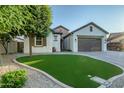 Beautiful home exterior with lush green grass, appealing stonework accents, and mature landscaping at 15803 W Almeria Rd, Goodyear, AZ 85395