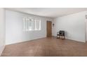 Simple living room with tiled floors and a large window at 230 E Fairmont Dr, Tempe, AZ 85282