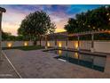 Backyard features a pool and patio, with trees and lighting in the background at 2774 E Valencia St, Gilbert, AZ 85296