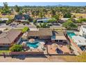 Aerial view of a private backyard with a sparkling pool, patio, a fire pit and lush landscaping in a residential neighborhood at 2847 S Bala Dr, Tempe, AZ 85282