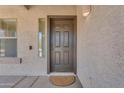 Elegant front door with sidelight window and a welcoming doormat on a covered porch at 29368 N Red Finch Dr, San Tan Valley, AZ 85143