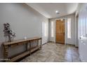 Bright foyer featuring tile flooring, a wooden console table, and sidelight windows flanking the entry door at 3088 E Andre Ave, Gilbert, AZ 85298