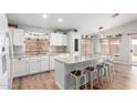 Bright kitchen featuring white cabinetry, a central island with barstool seating, and modern appliances at 4837 E Whitehall Dr, San Tan Valley, AZ 85140