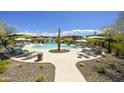 Community pool area featuring desert landscaping, shaded seating, and lounge chairs at 5100 E Rancho Paloma Dr # 1029, Cave Creek, AZ 85331
