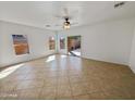 Bright living room features tile flooring, a ceiling fan, and sliding door access to the outdoor space at 5339 W Maldonado Rd, Laveen, AZ 85339