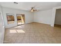 Open-concept living room with tile flooring, a sliding glass door to the backyard, and a bright, airy feel at 5339 W Maldonado Rd, Laveen, AZ 85339