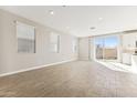 Spacious living room with wood-look tile, recessed lighting, and large windows, providing abundant natural light at 5827 E Covey Ln, Phoenix, AZ 85054