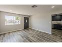 Bright living room with wood-look floors, recessed lighting, and a large window for natural light at 662 W Elena Ave, Mesa, AZ 85210
