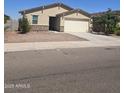 Tan single-story home with a stone veneer accent, desert landscaping, and a two car garage on a sunny day at 7321 N 123Rd Dr, Glendale, AZ 85307