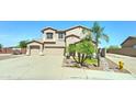 Traditional two-story home featuring a three-car garage, desert landscaping, and a charming front entrance at 7398 W Paso Trl, Peoria, AZ 85383
