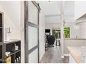 Hallway with gray sliding door and view into living room with plenty of natural light at 8210 E Garfield St # K23, Scottsdale, AZ 85257