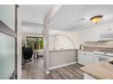 Open concept kitchen includes white cabinets, stone countertops, and views of the living space at 8210 E Garfield St # K23, Scottsdale, AZ 85257