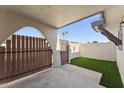 Private patio with wood fence, metal access gate, and an outdoor storage area with artificial grass at 830 S Dobson Rd # 19, Mesa, AZ 85202
