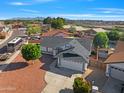 An aerial view shows a well-maintained home in a quiet neighborhood with mountain views at 8620 W Denton Ln, Glendale, AZ 85305