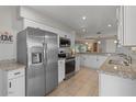 Bright kitchen featuring stainless steel appliances, granite countertops, and white cabinetry at 10895 W Clair Dr, Sun City, AZ 85351