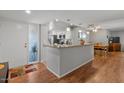 Open-concept kitchen and living area with a spacious breakfast bar and hardwood floors at 10895 W Clair Dr, Sun City, AZ 85351