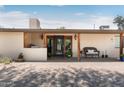Charming covered patio with brick flooring, wooden posts, and decorative accents at the front entrance at 12212 N 66Th St, Scottsdale, AZ 85254