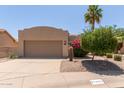Charming single-story home with a two-car garage, desert landscaping, and a palm tree in the front yard at 13041 S 45Th Pl, Phoenix, AZ 85044