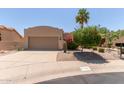 Charming single-story home with a two-car garage, desert landscaping, and a palm tree in the front yard at 13041 S 45Th Pl, Phoenix, AZ 85044