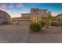 Two-story home with a well-maintained yard, three-car garage, and desert landscaping at 13824 W Gelding Dr, Surprise, AZ 85379