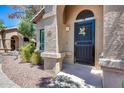 Close-up of the front door with a decorative security screen and desert-style landscaping at 14300 W Bell Rd # 312, Surprise, AZ 85374