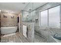 An elegant main bathroom features a glass shower with bench and a separate soaking tub at 14517 W Cortez St, Surprise, AZ 85379