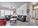 Comfortable living room featuring tile floors, bright windows, and ample seating space at 17317 N Ponca Way, Surprise, AZ 85374