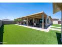 Expansive covered patio perfect for outdoor entertaining with lush green artificial grass at 17547 W Gambit Trl, Surprise, AZ 85387