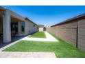 Manicured backyard with artificial turf providing a lush and low-maintenance outdoor space at 17547 W Gambit Trl, Surprise, AZ 85387