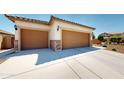 Three-car garage with concrete driveway, offering ample parking and convenient access at 17547 W Gambit Trl, Surprise, AZ 85387