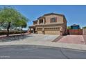 Two-story home featuring a three-car garage, landscaped front yard, and a large driveway with RV gate at 1932 S 220Th Dr, Buckeye, AZ 85326