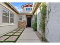 Inviting front entrance with stone accents, lush greenery, and stylish walkway, creating a welcoming curb appeal at 19748 E Walnut Rd, Queen Creek, AZ 85142