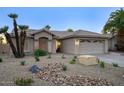 Single-story home featuring a tile roof, palm trees, well-kept landscaping, and a two-car garage at 19906 N 76Th Ave, Glendale, AZ 85308