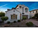 Inviting two-story home displaying neat desert landscaping and a brick paved driveway at 21194 W Hillcrest Blvd, Buckeye, AZ 85396