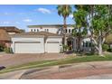 Charming front exterior with a three-car garage, well-maintained lawn, and mature palm trees at 2135 E Clipper Ln, Gilbert, AZ 85234