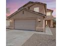 Charming two-story home featuring a neutral color palette, a two-car garage, and a well-maintained front yard at 22328 W Woodlands Ave, Buckeye, AZ 85326