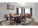 Traditional dining room with a wooden table, seating for eight, and modern lighting fixture on luxury vinyl plank flooring at 25409 N 40Th Ln, Phoenix, AZ 85083