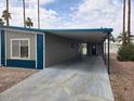 Side view of the manufactured home showing the covered parking area and the exterior of the building at 3104 E Broadway Rd # 207, Mesa, AZ 85204