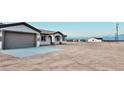 View of house with a large attached two-car garage and desert landscape at 35672 W Chipman Rd, Tonopah, AZ 85354