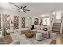 Bright living room with a large sectional sofa, modern ceiling fan, and stylish decor for a welcoming ambiance at 3692 N 292Nd Dr, Buckeye, AZ 85396